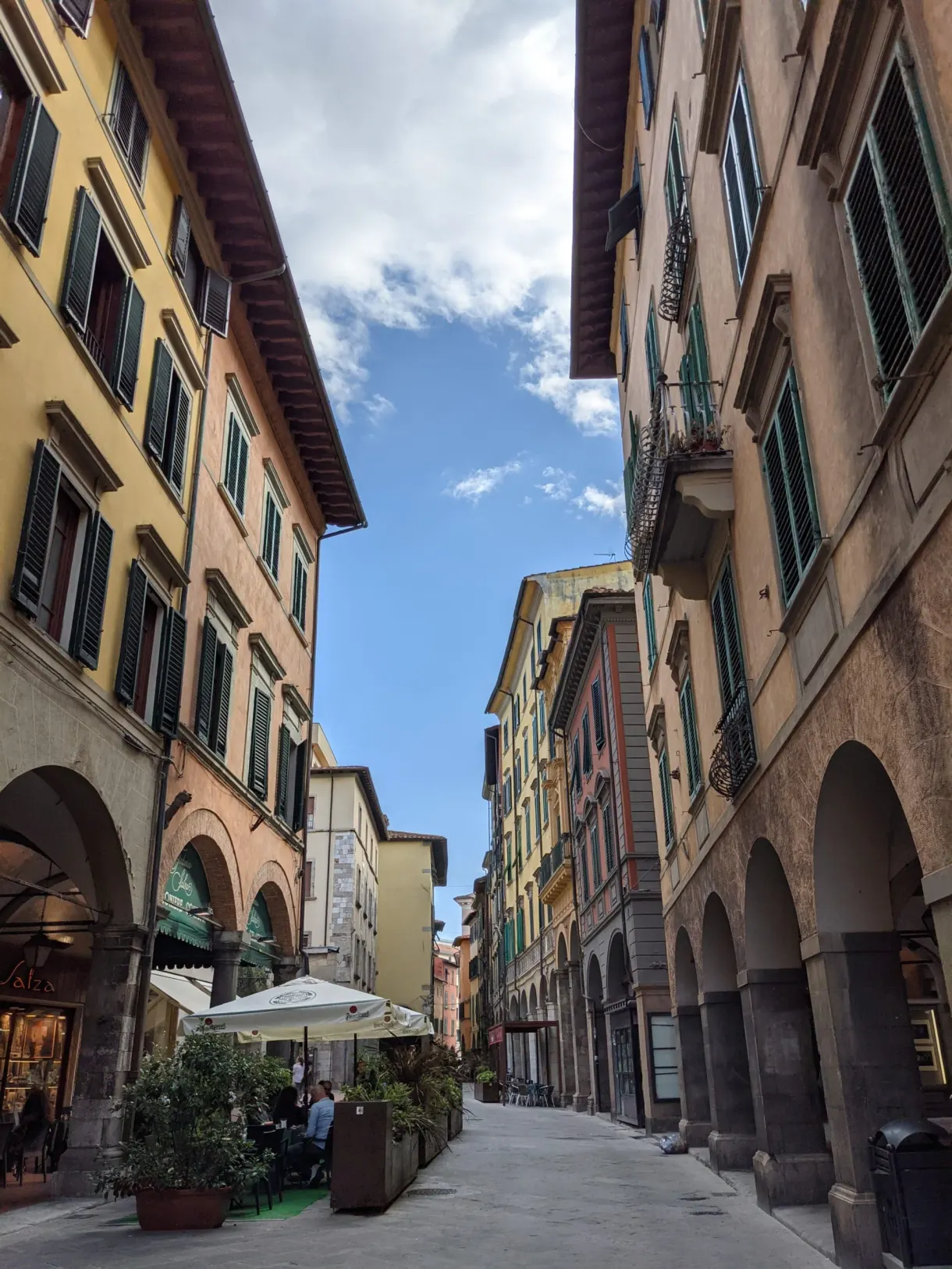 Rue commerçante sous les arcades avec ses terrasses de café