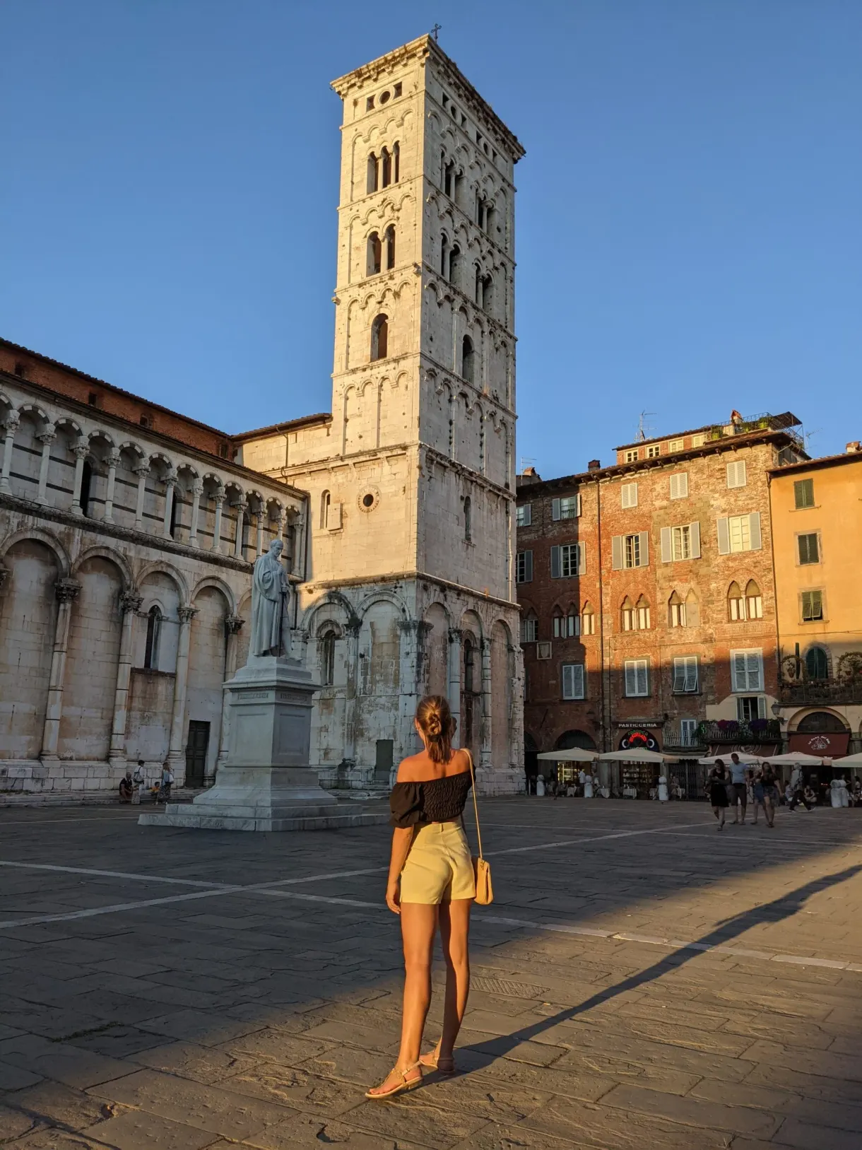 Passante traversant la place devant une église romane