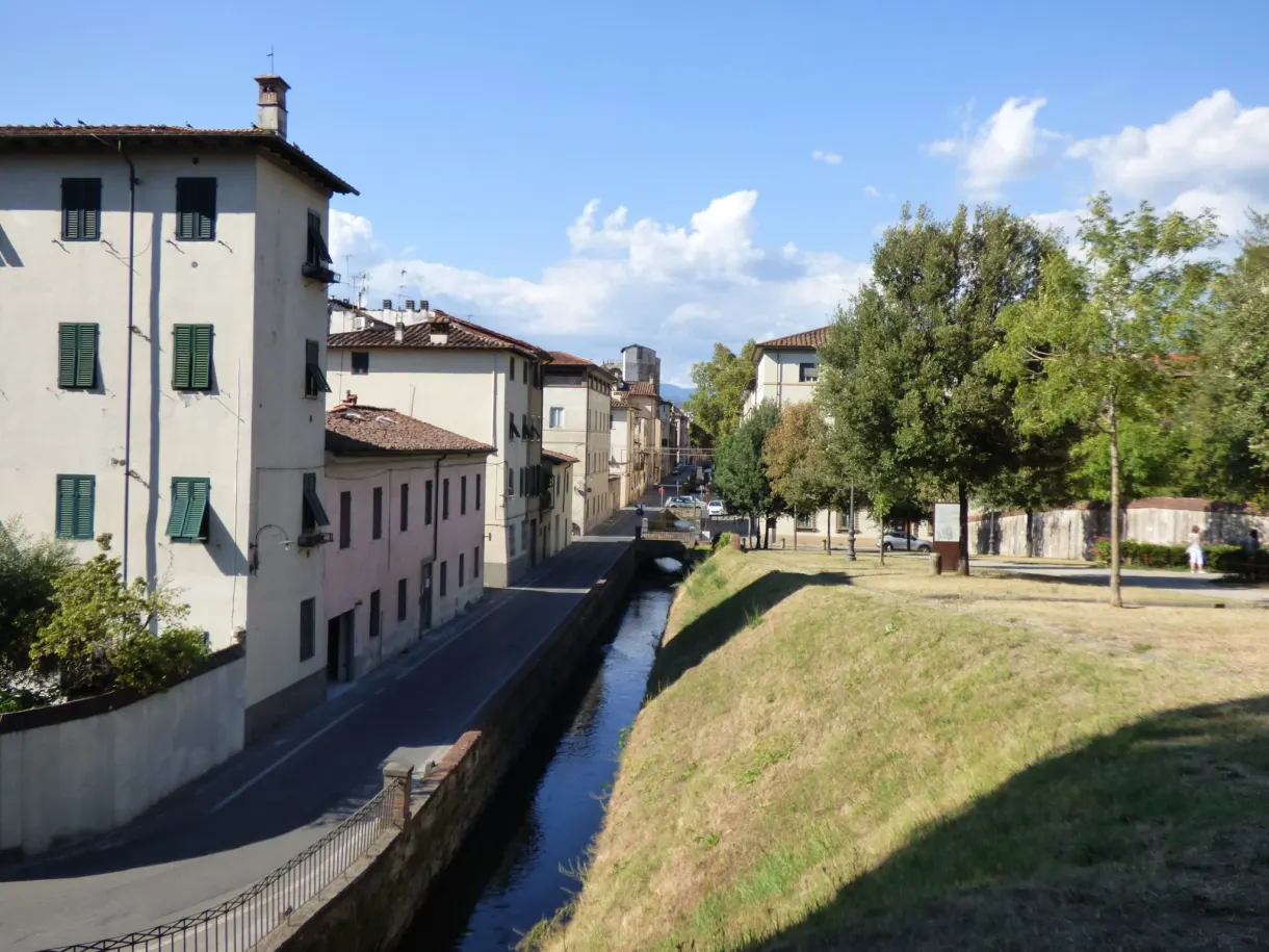Canal étroit longeant les maisons au pied des remparts