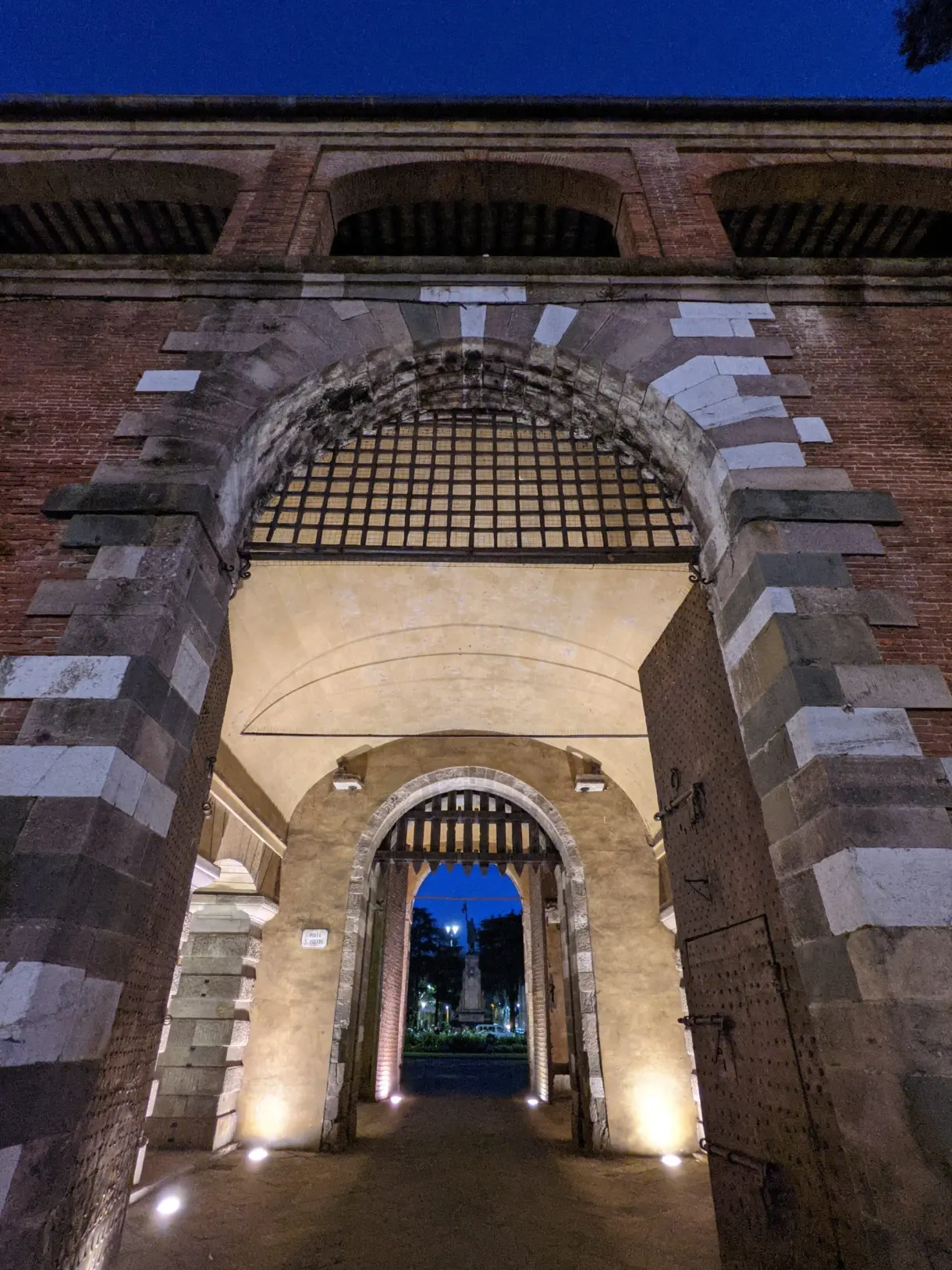 Porte fortifiée en brique éclairée à la tombée du soir