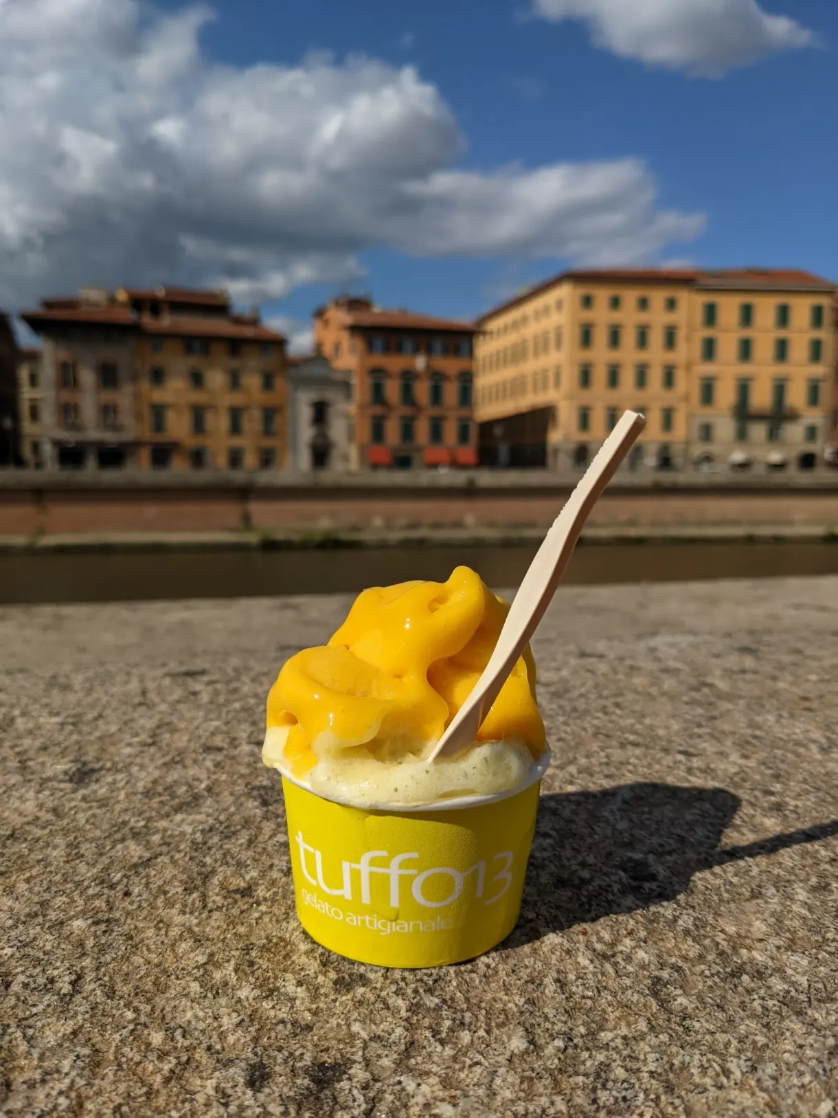 Glace à la mangue posée sur un parapet face aux façades
