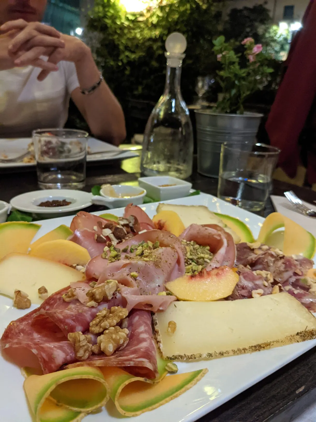 Assiette de charcuterie, melon et fromage partagée à table