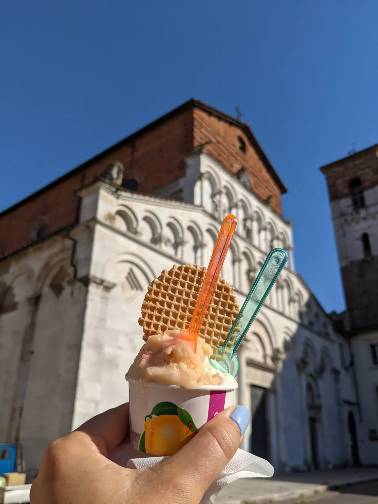 Glace à deux parfums brandie devant une église de marbre