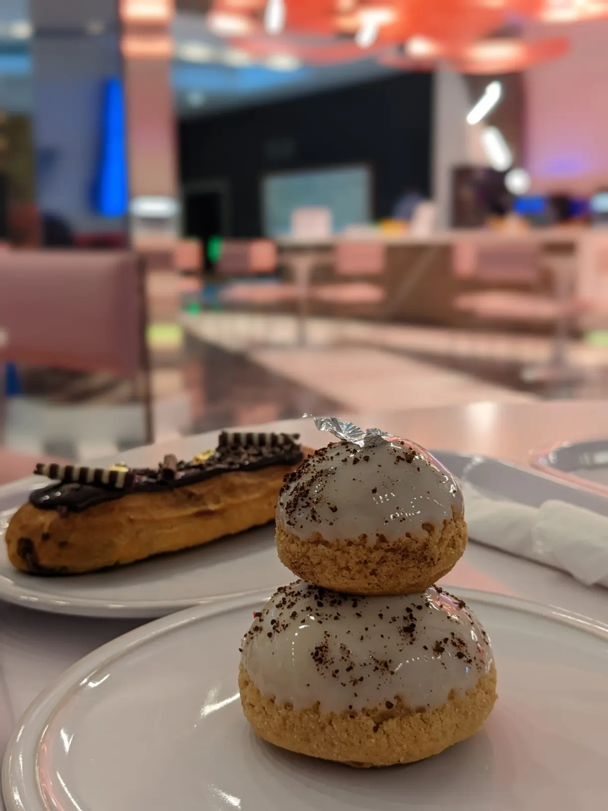 Choux glacés et éclair posés sur une assiette blanche