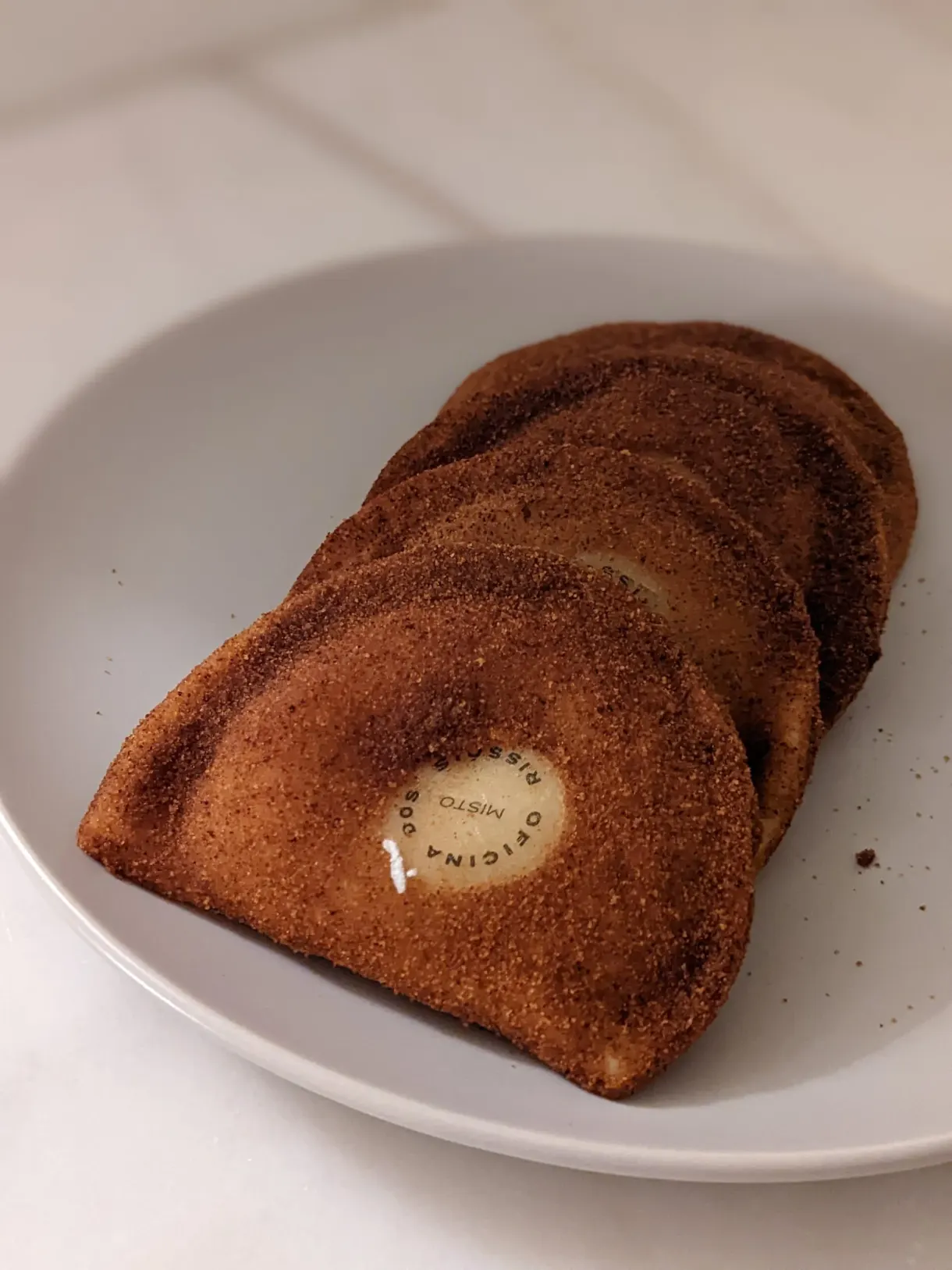 Chaussons frits saupoudrés de sucre dans une assiette