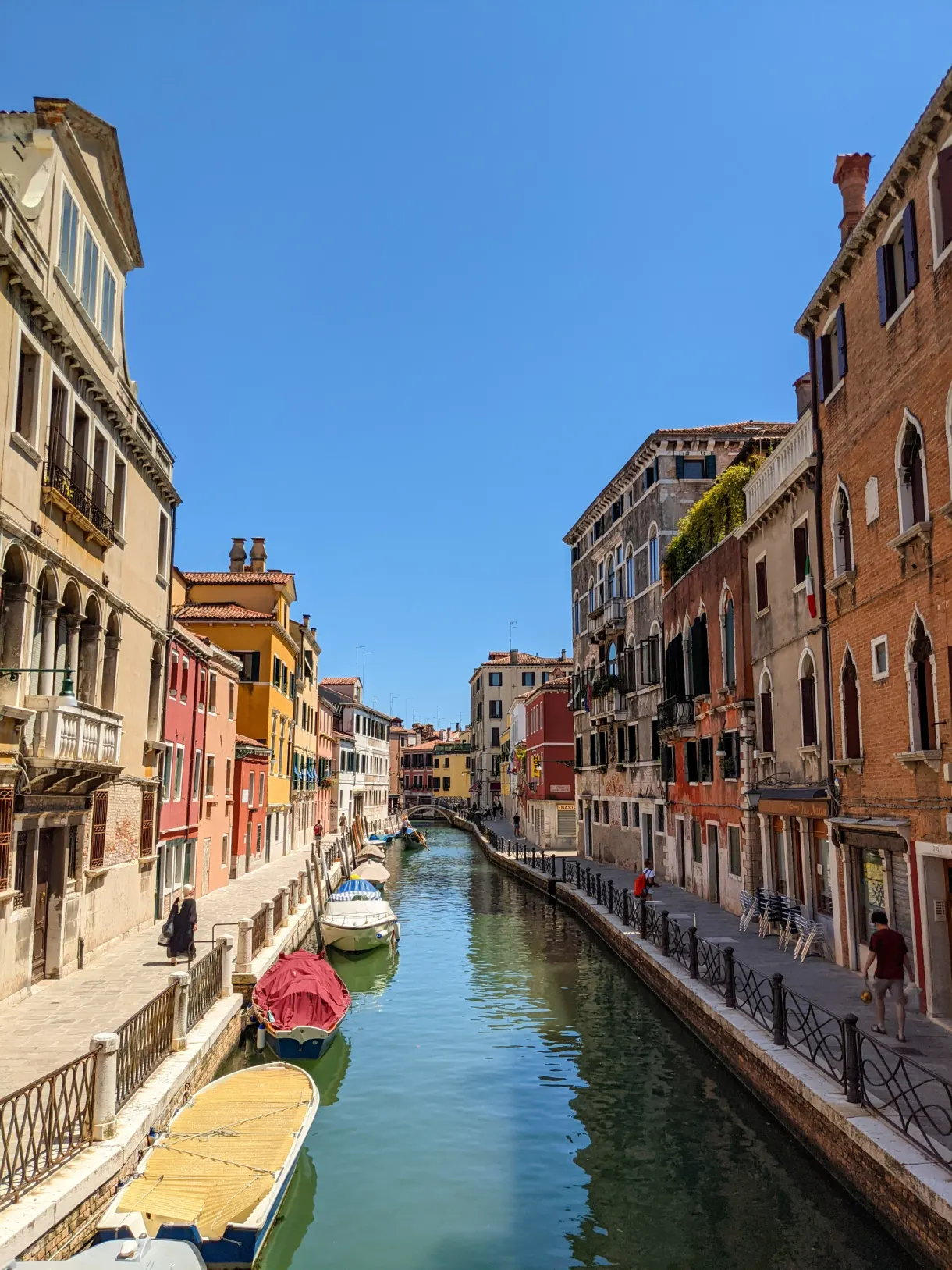 Narrow Venetian canal lined with palaces with ochre facades