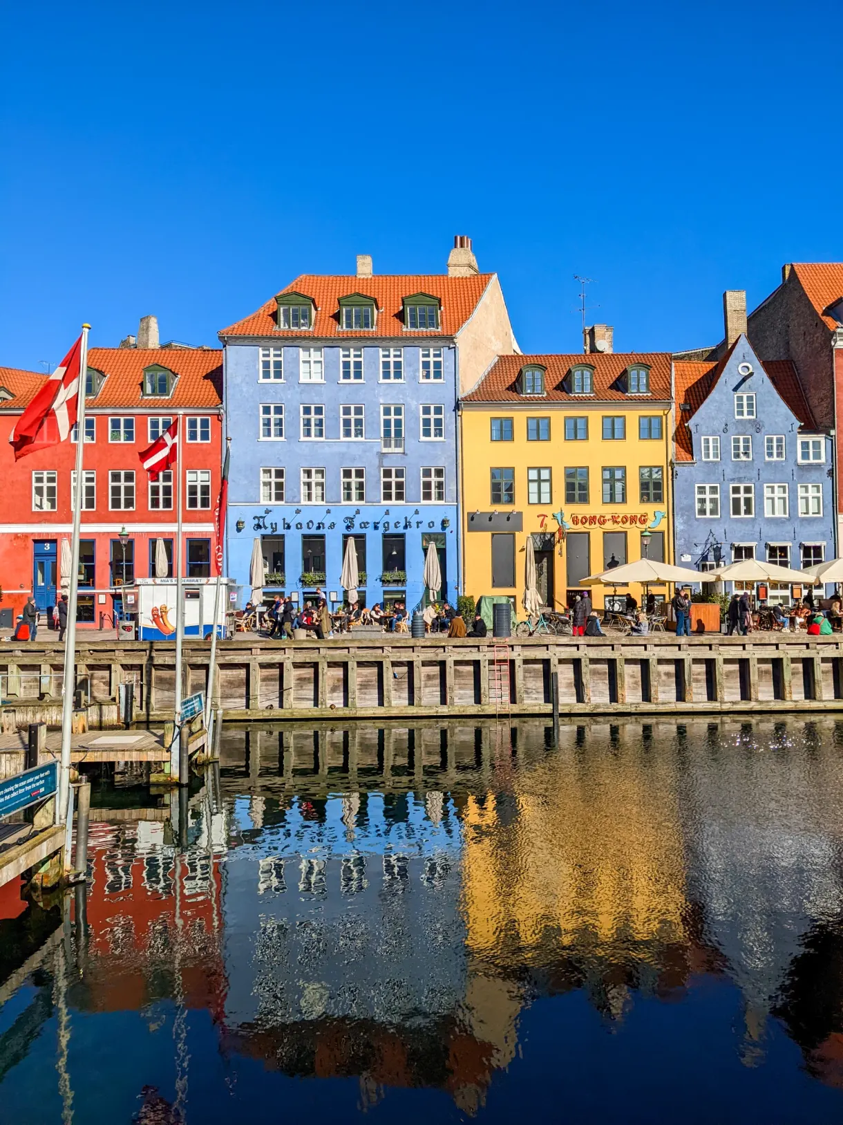 Façades colorées de Nyhavn et drapeau danois au bord du canal