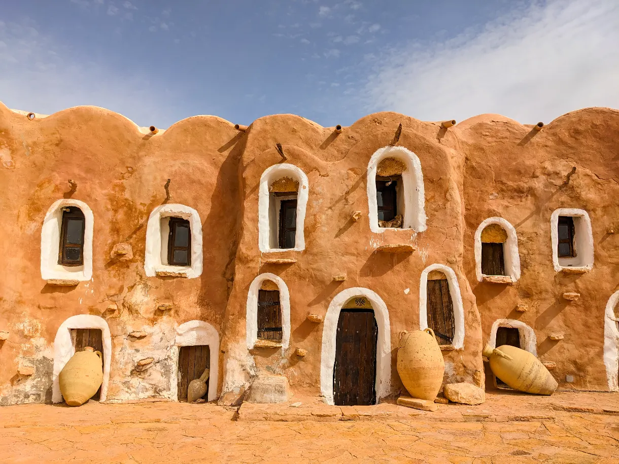 Ksour, greniers à grain en terre ocre du sud de la Tunisie, avec des jarres en céramique devant