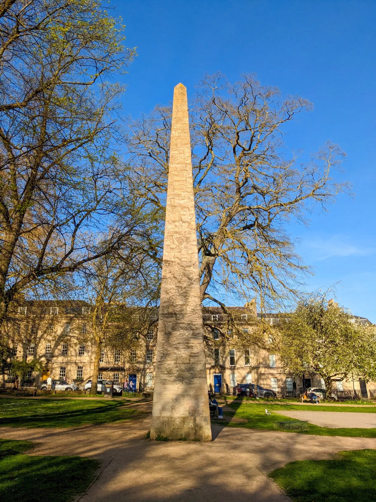 obélisque au centre d'une place arborée à Bath