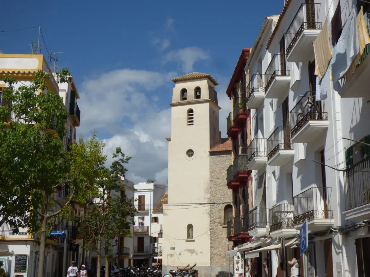 Clocher blanc d'une église coincé entre des immeubles