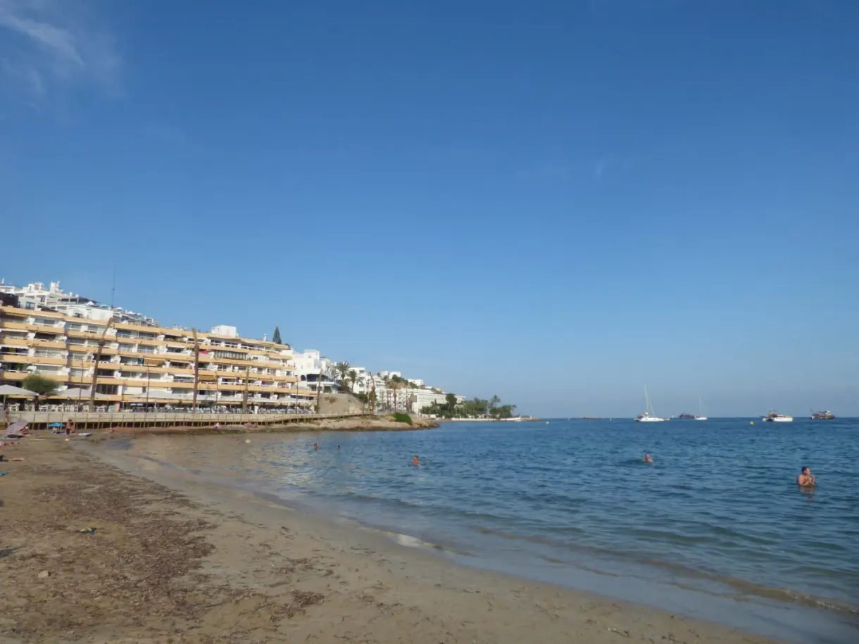 Plage de sable bordée d'immeubles et d'eau limpide