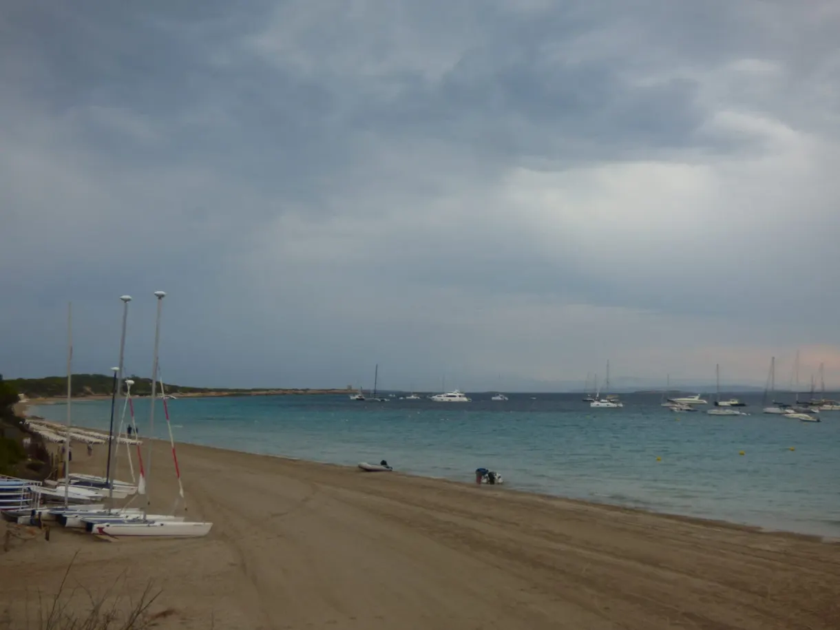Catamarans tirés sur le sable sous un ciel chargé