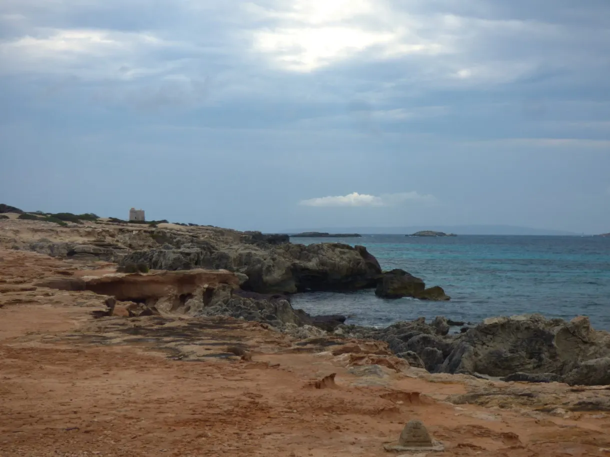 Rochers ocre plongeant dans une mer d'étain