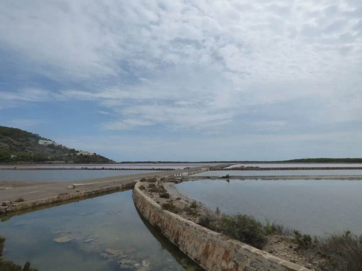 Digue de pierre séparant deux bassins réfléchissant le ciel