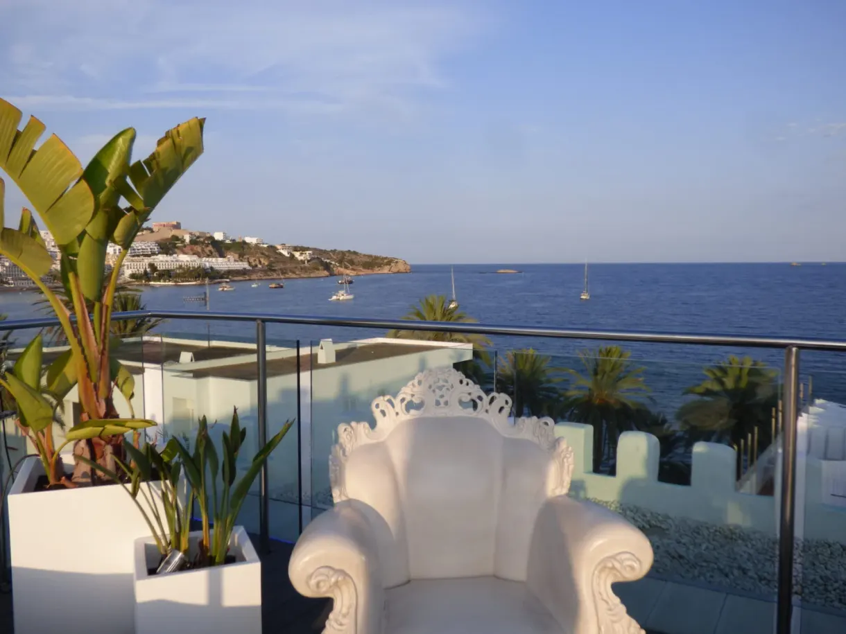 Fauteuil baroque blanc sur une terrasse ouverte sur la mer