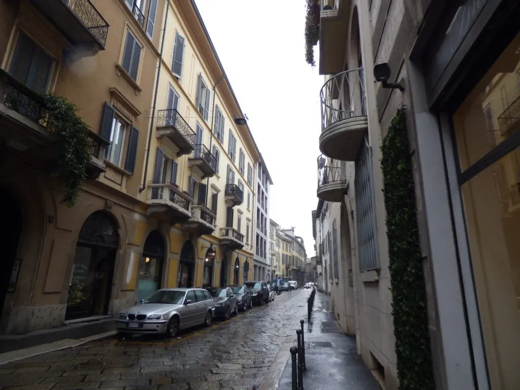 Rue étroite luisante de pluie bordée d'immeubles à balcons
