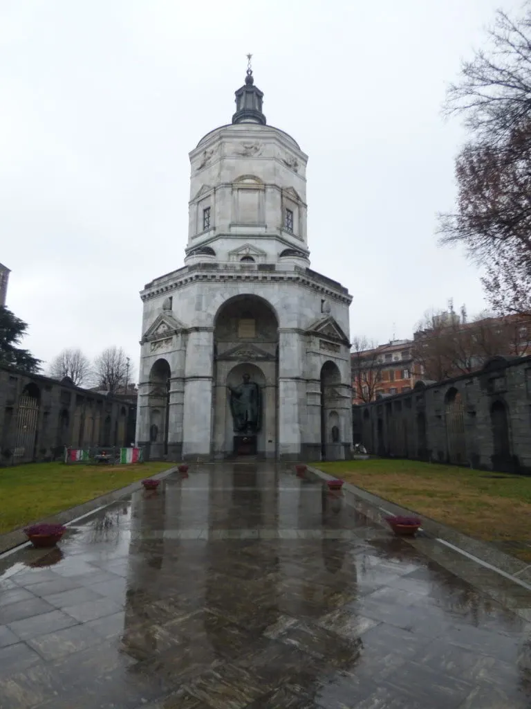 Rotonde de pierre au bout d'un bassin sous la pluie
