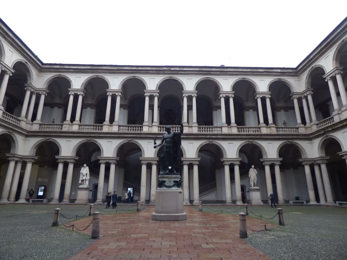 Cour à double étage d'arcades avec statue de bronze au centre