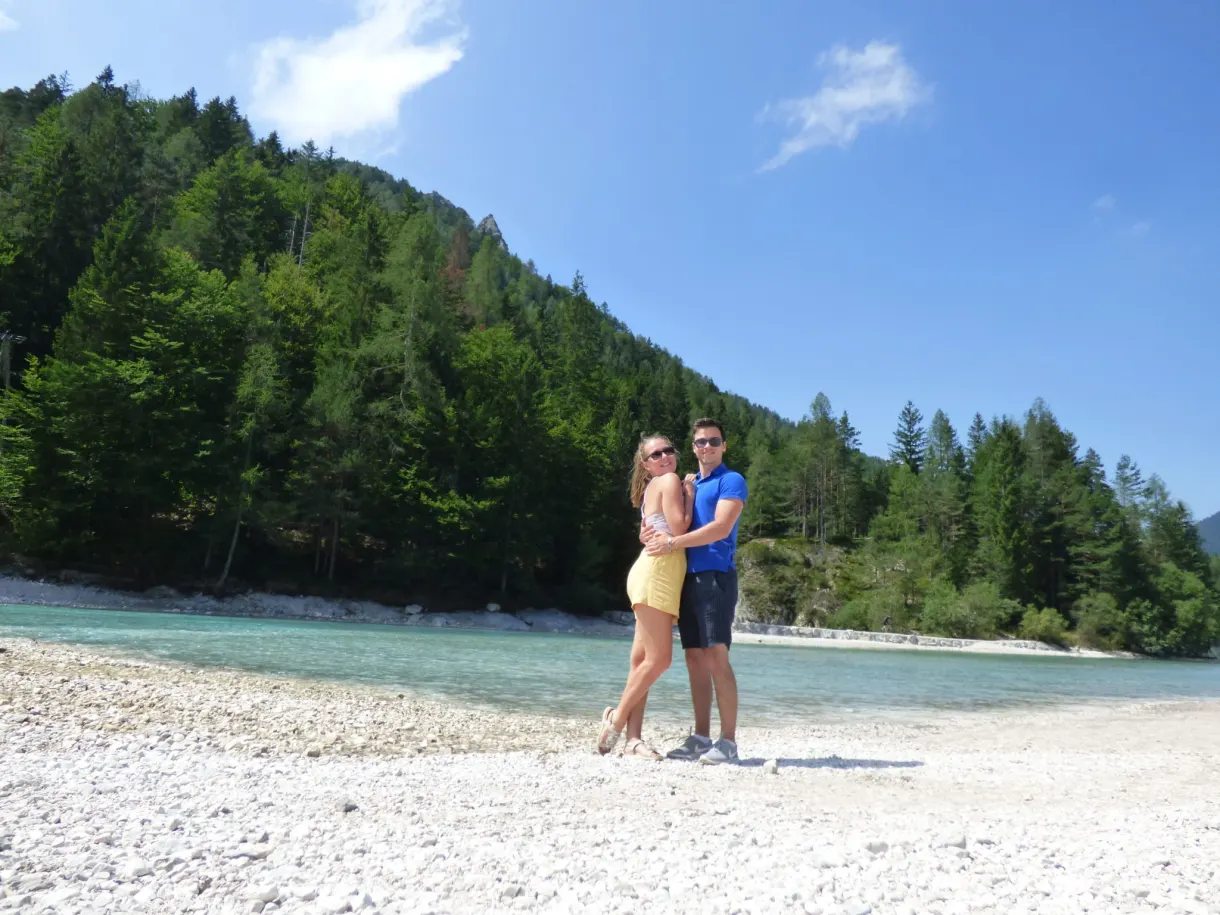 Couple posant sur la rive de galets du lac