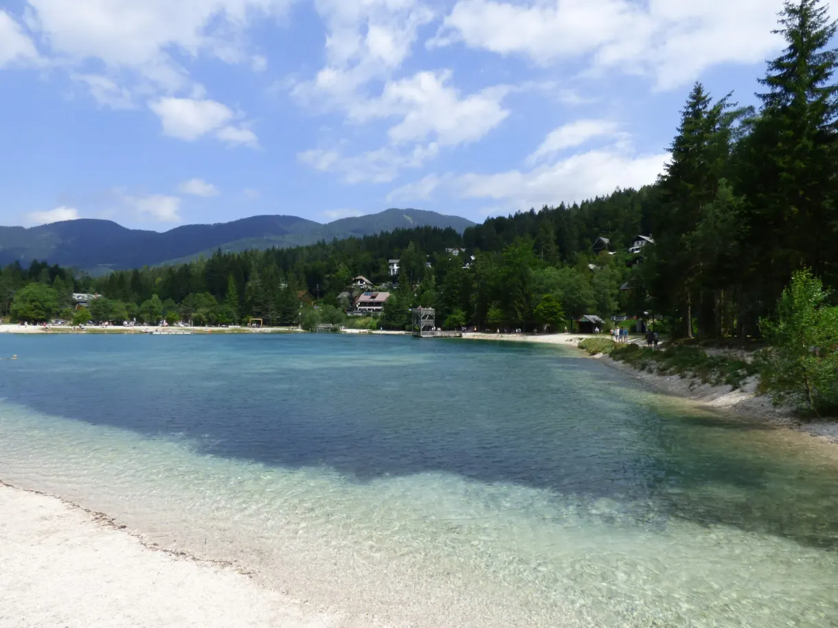 Lac turquoise cerné de forêts et de chalets