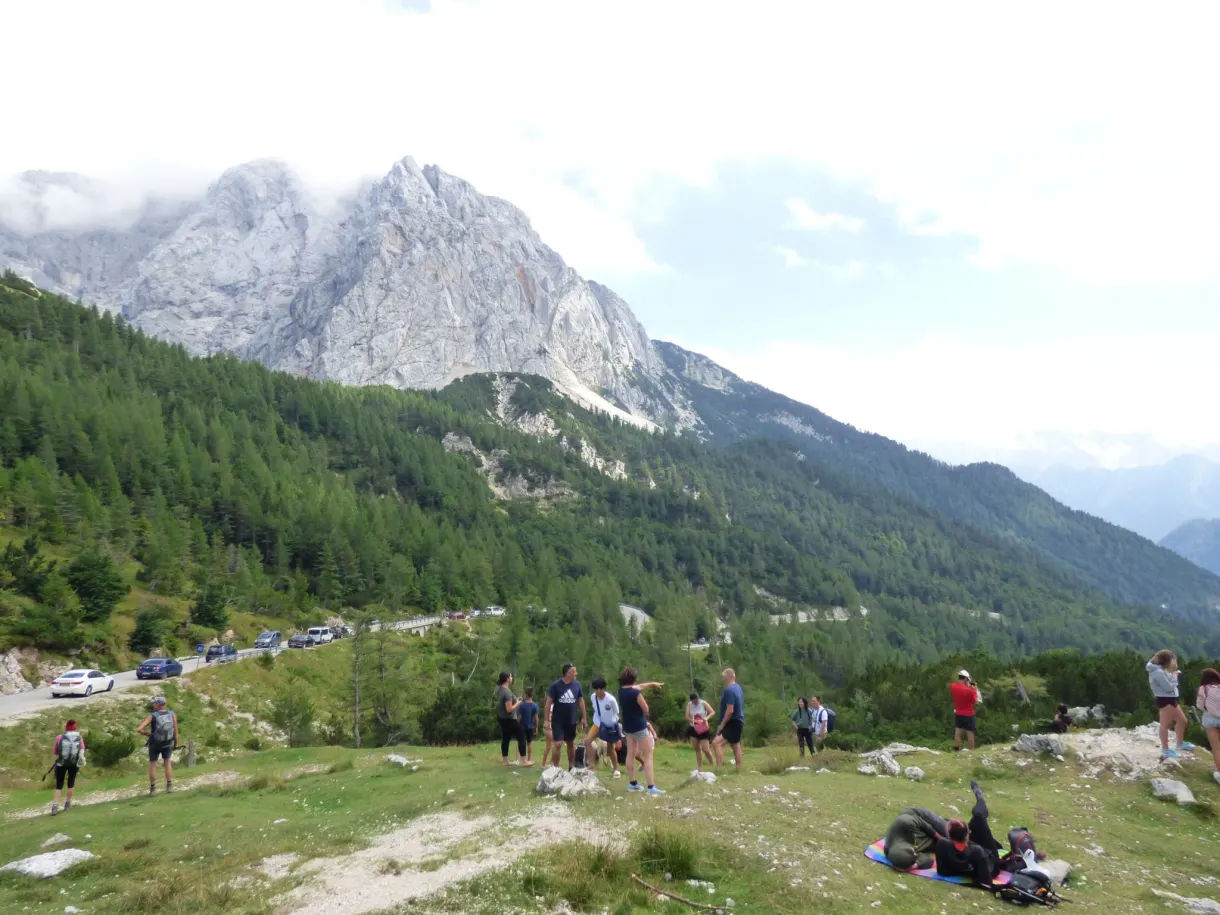 Randonneurs rassemblés devant les sommets voilés de nuages