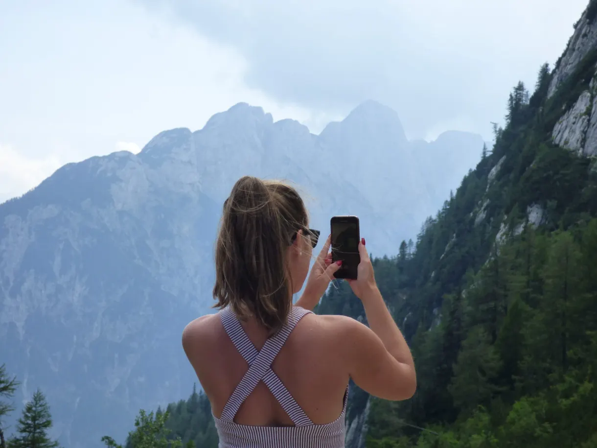 Femme photographiant les sommets avec son téléphone