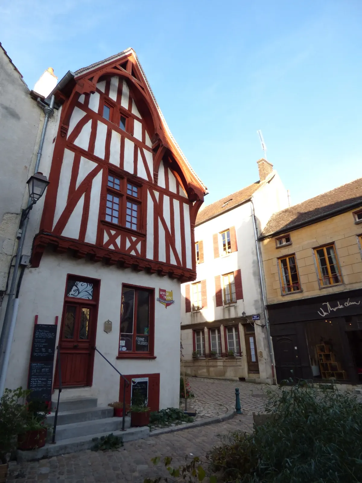 Maison à colombages rouge et blanc au coin d'une place