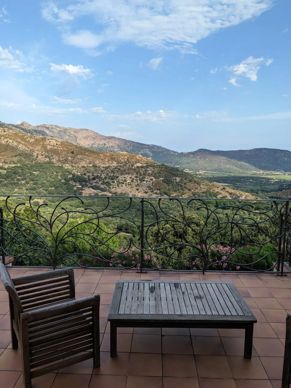 Terrasse carrelée ouverte sur la vallée verdoyante