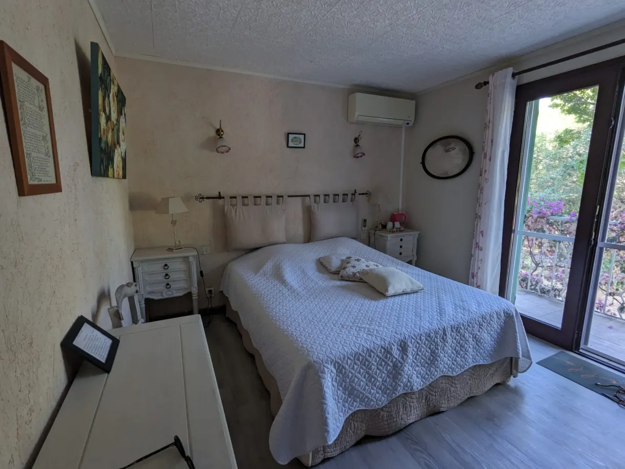 Chambre claire ouvrant par une grande baie sur le jardin