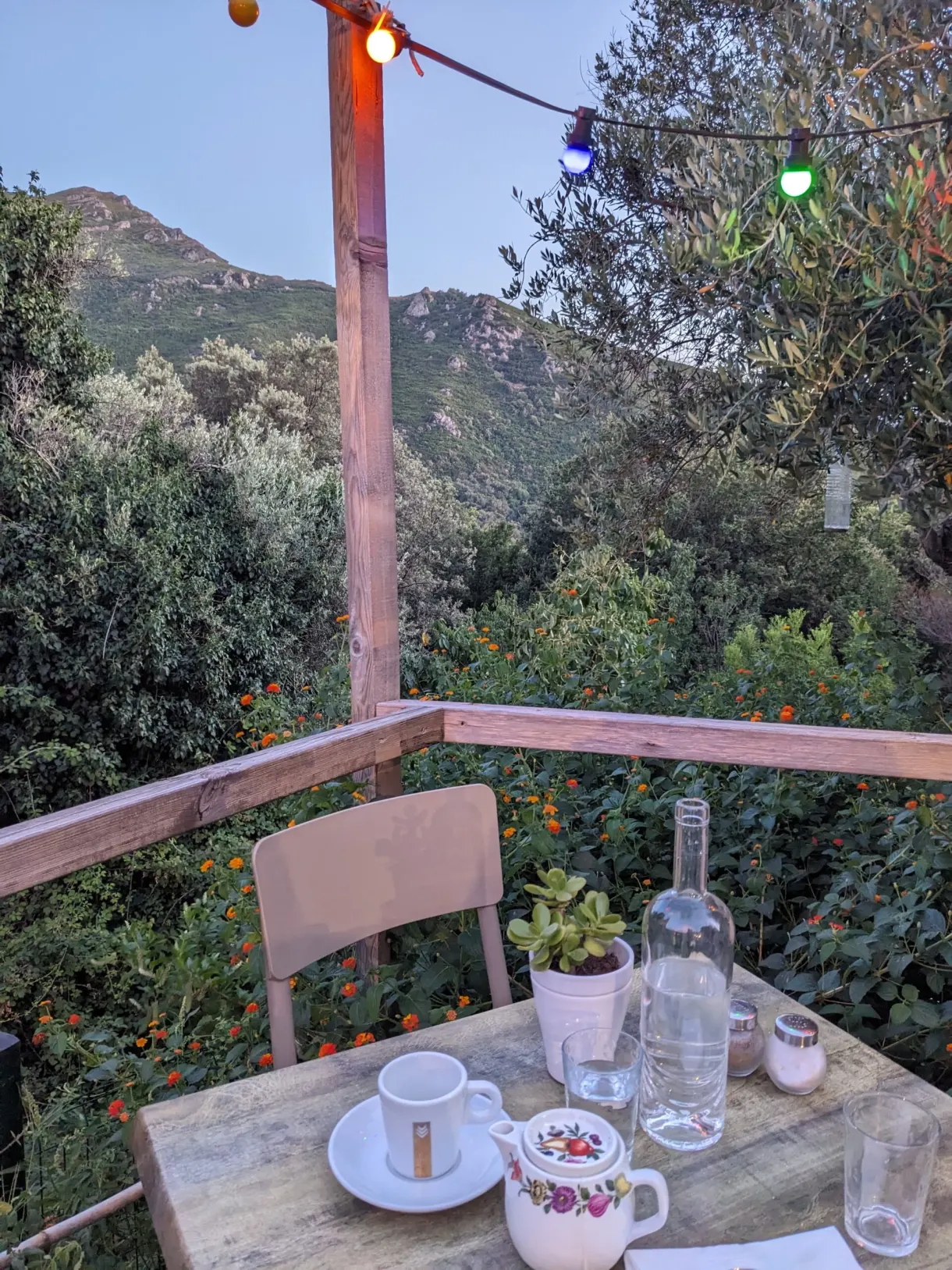 Café du matin sur une table de terrasse sous les guirlandes