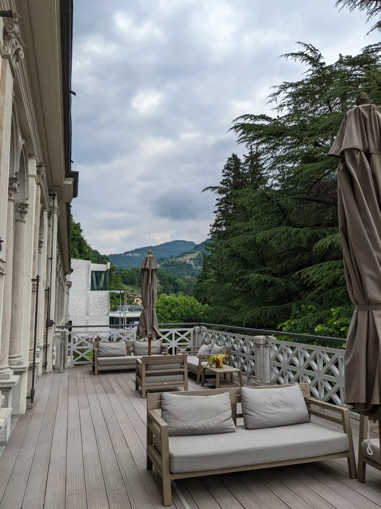 Canapés et parasols repliés sur une terrasse en bois