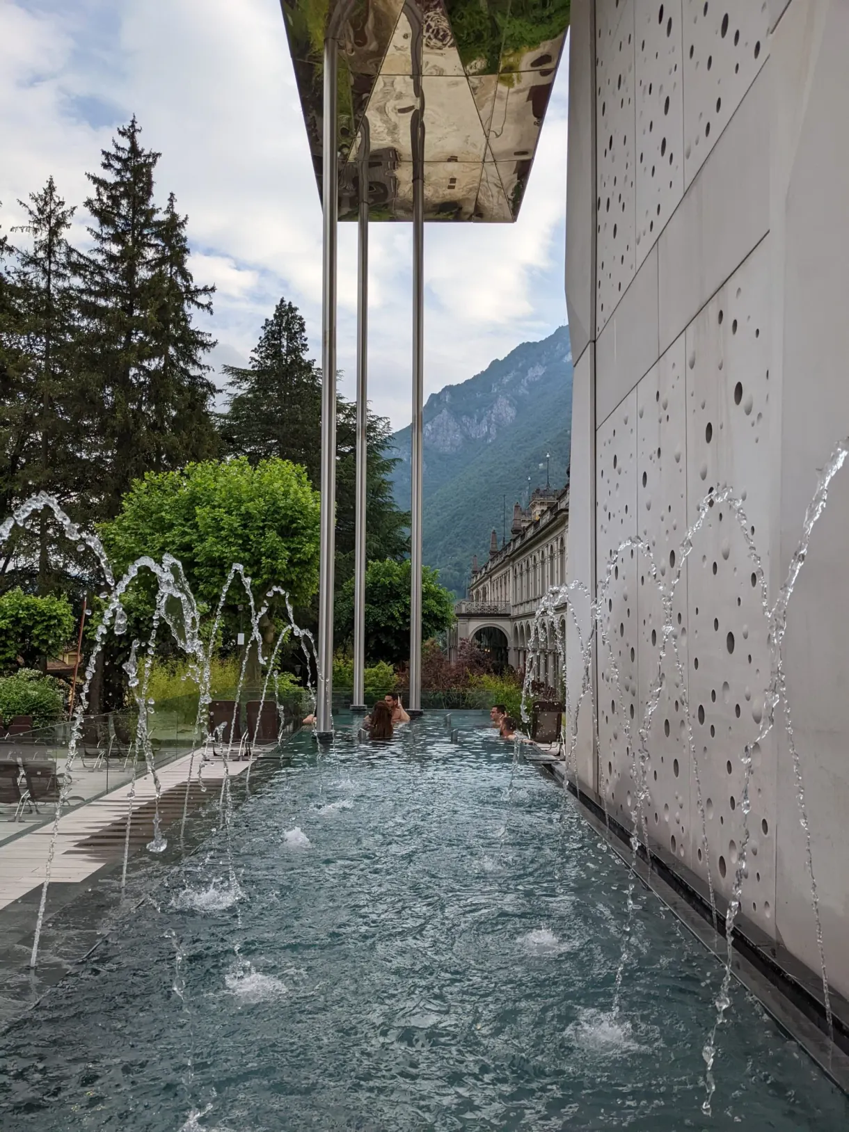 Jets d'eau au pied d'un bâtiment de béton clair