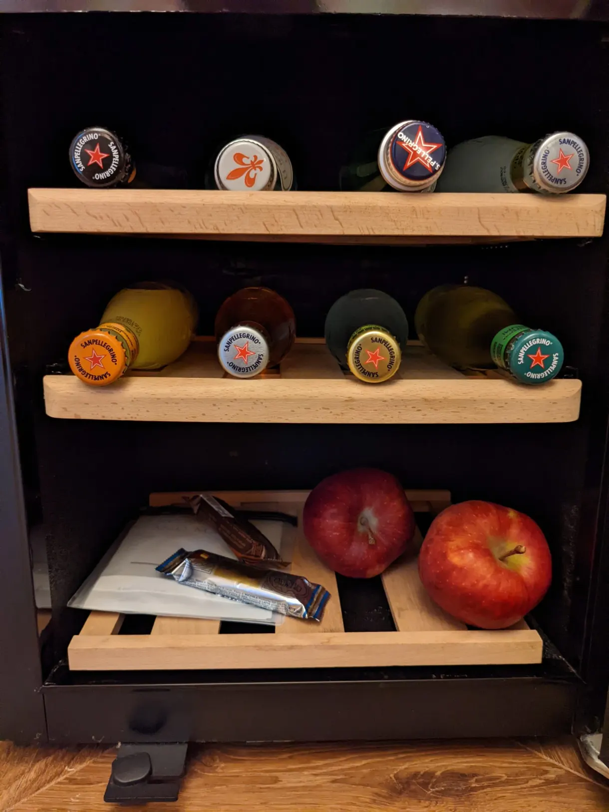 Minibar garni de bouteilles colorées et de pommes