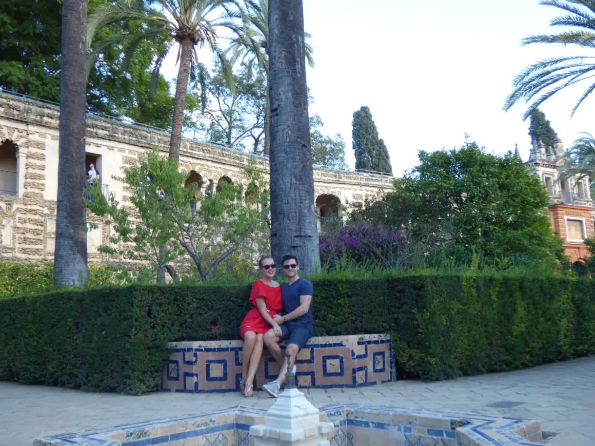 Couple assis sur un banc de céramique près d'une fontaine