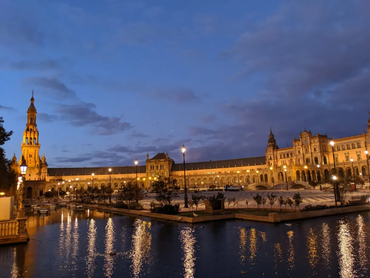 Palais illuminé et reflets dorés sur le canal, ciel bleu nuit