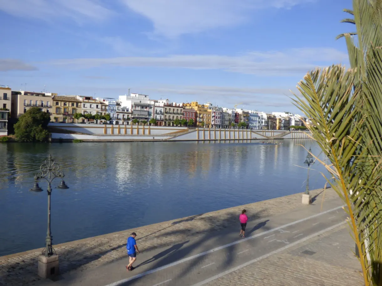 Quai du fleuve et pont blanc, promeneurs au soleil