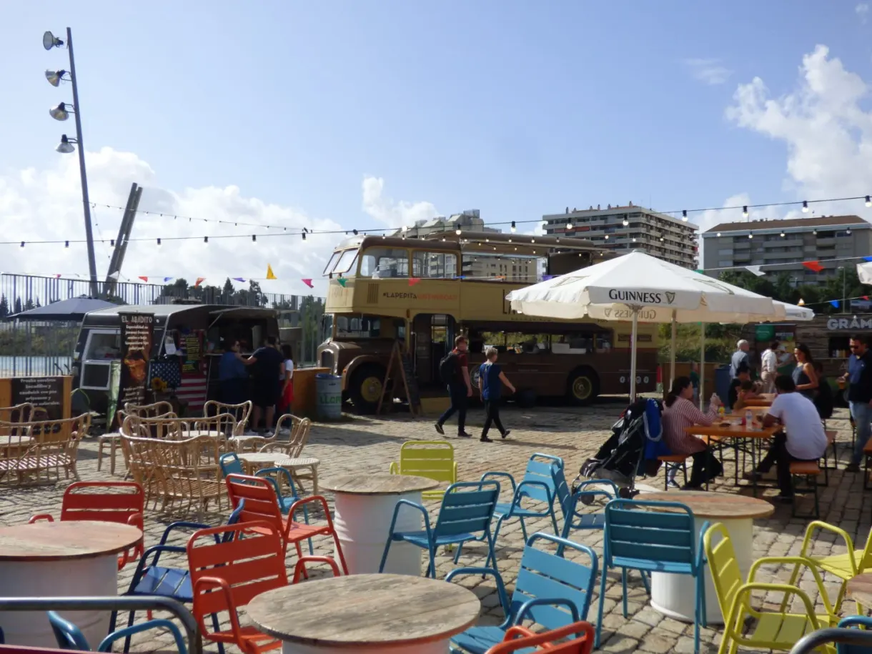 Terrasse de food trucks aux chaises colorées sur le quai