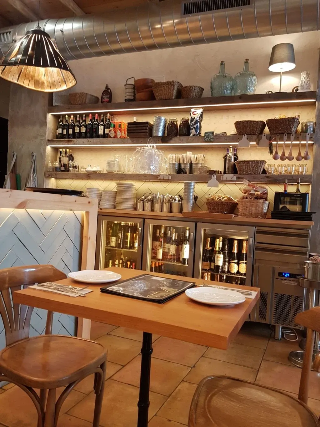 Table en bois et étagères de bocaux dans un restaurant