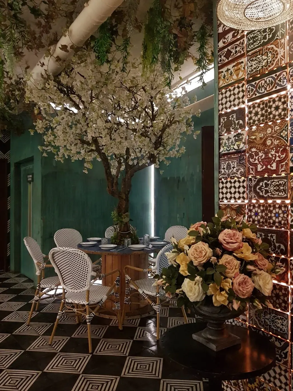 Salle à manger au sol damier, arbre fleuri et roses
