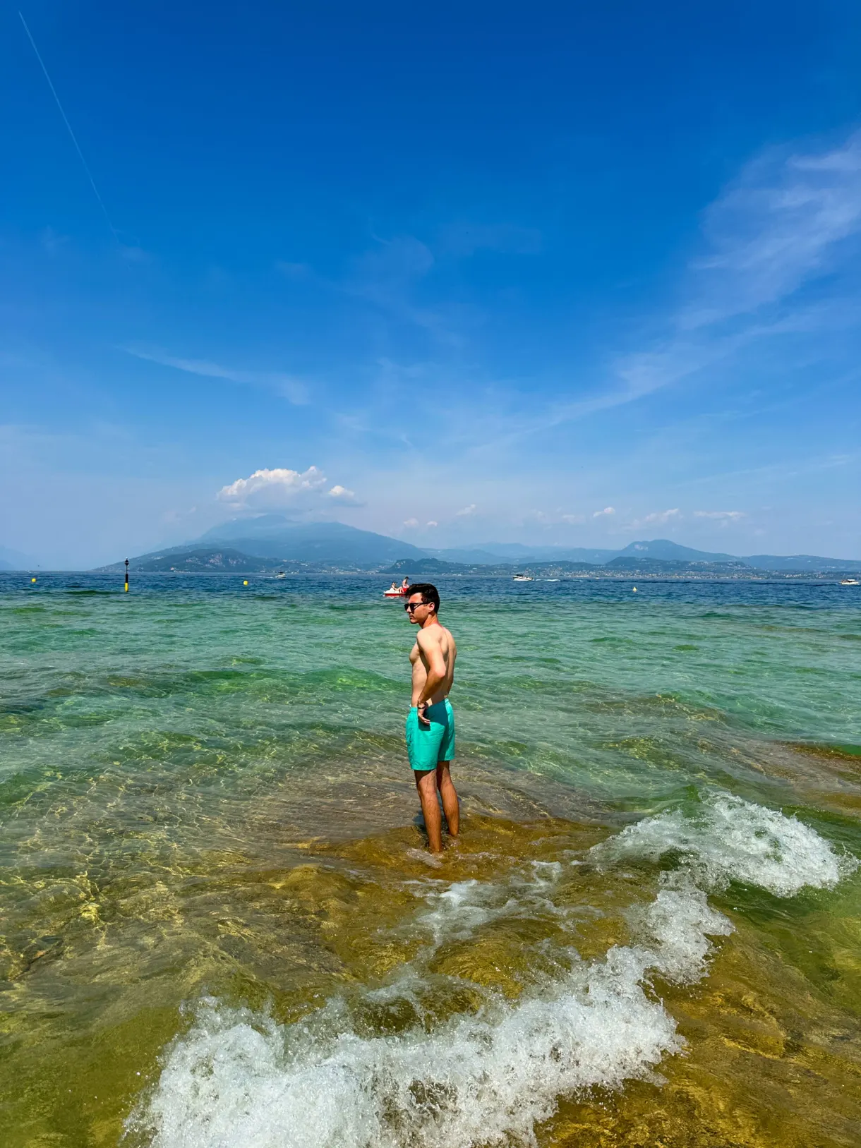 Homme les pieds dans les vagues du lac de Garde