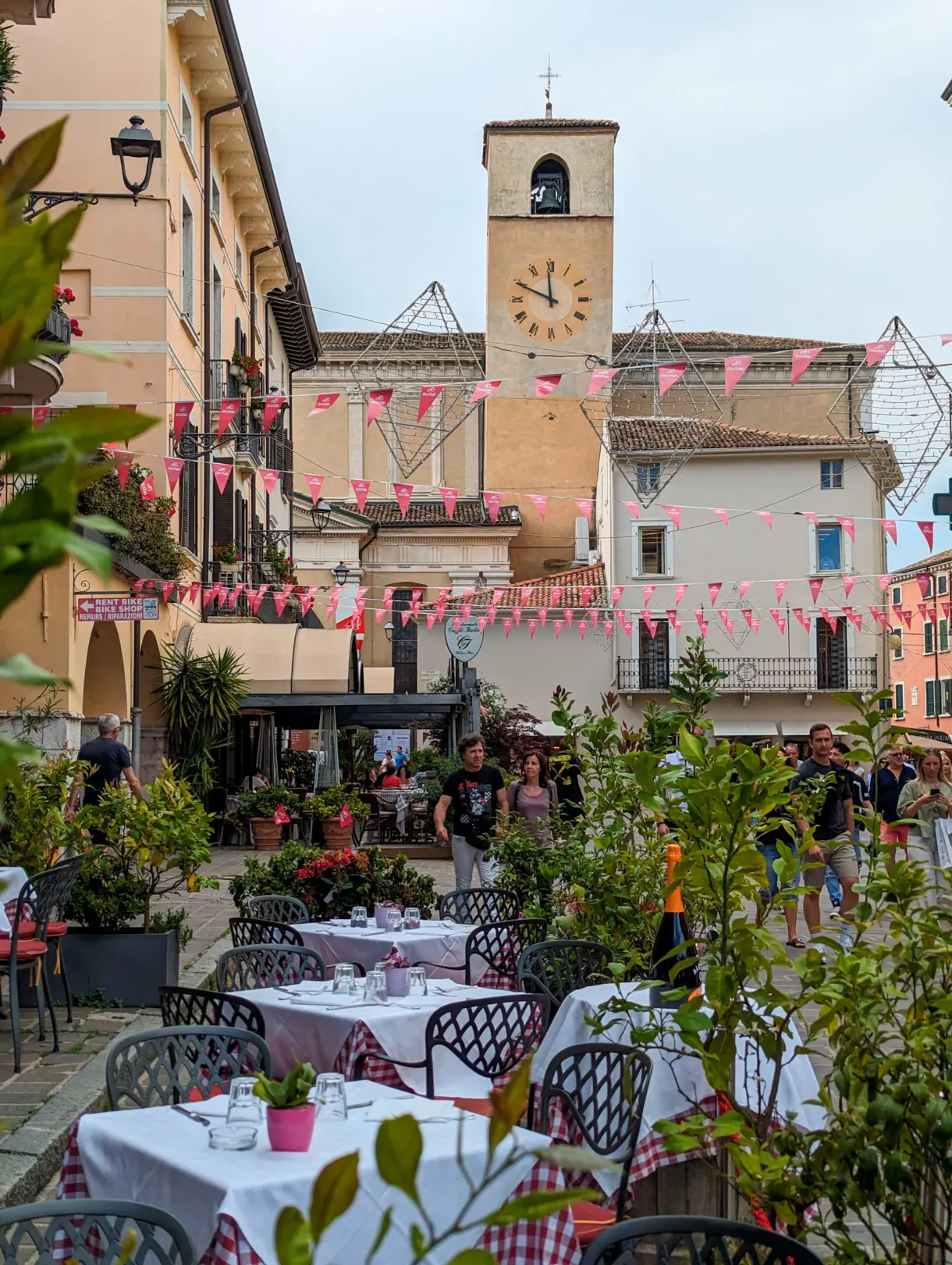 Terrasses et fanions roses sous la tour de l'horloge