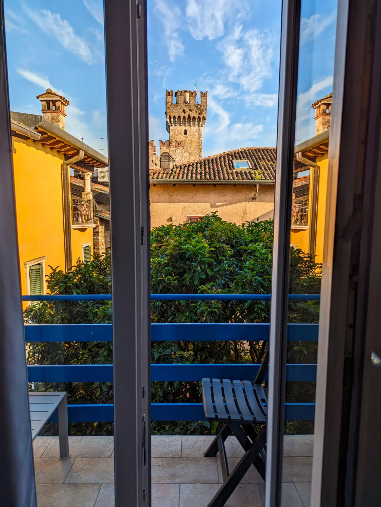 Balcon ouvert sur les toits jaunes et la tour du château