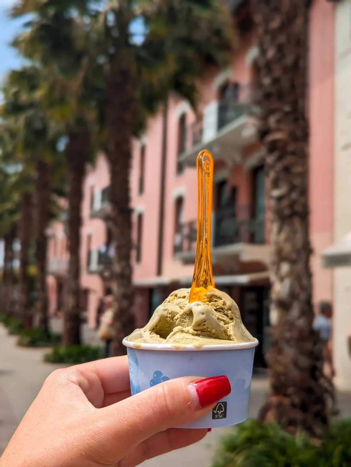Glace pistache tenue devant une allée de palmiers