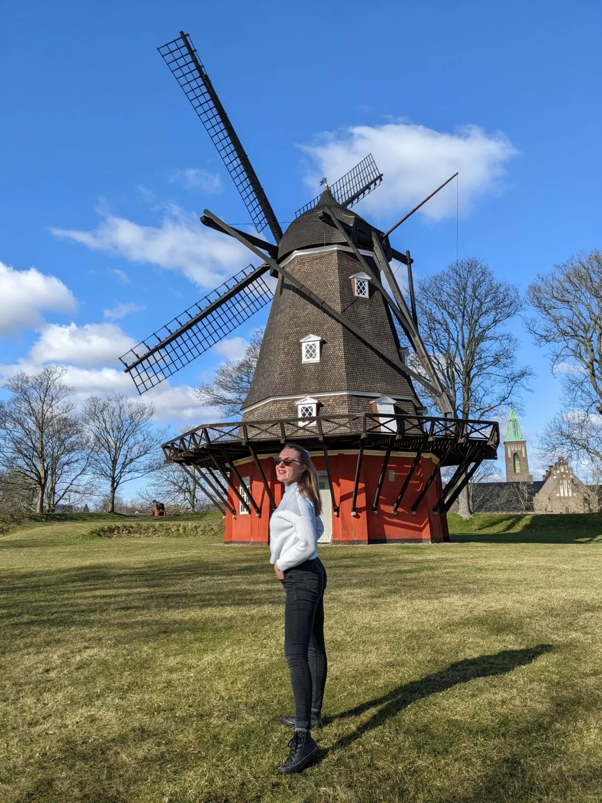 Voyageuse en chemise blanche devant le moulin à vent du Kastellet