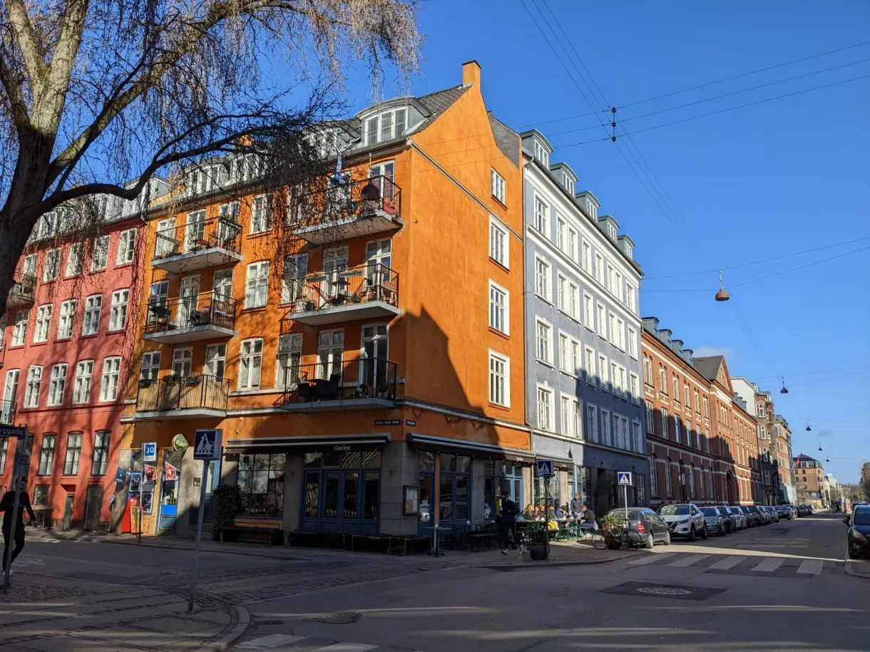 Immeuble d'angle orange et rue en perspective dans le quartier de Nørrebro