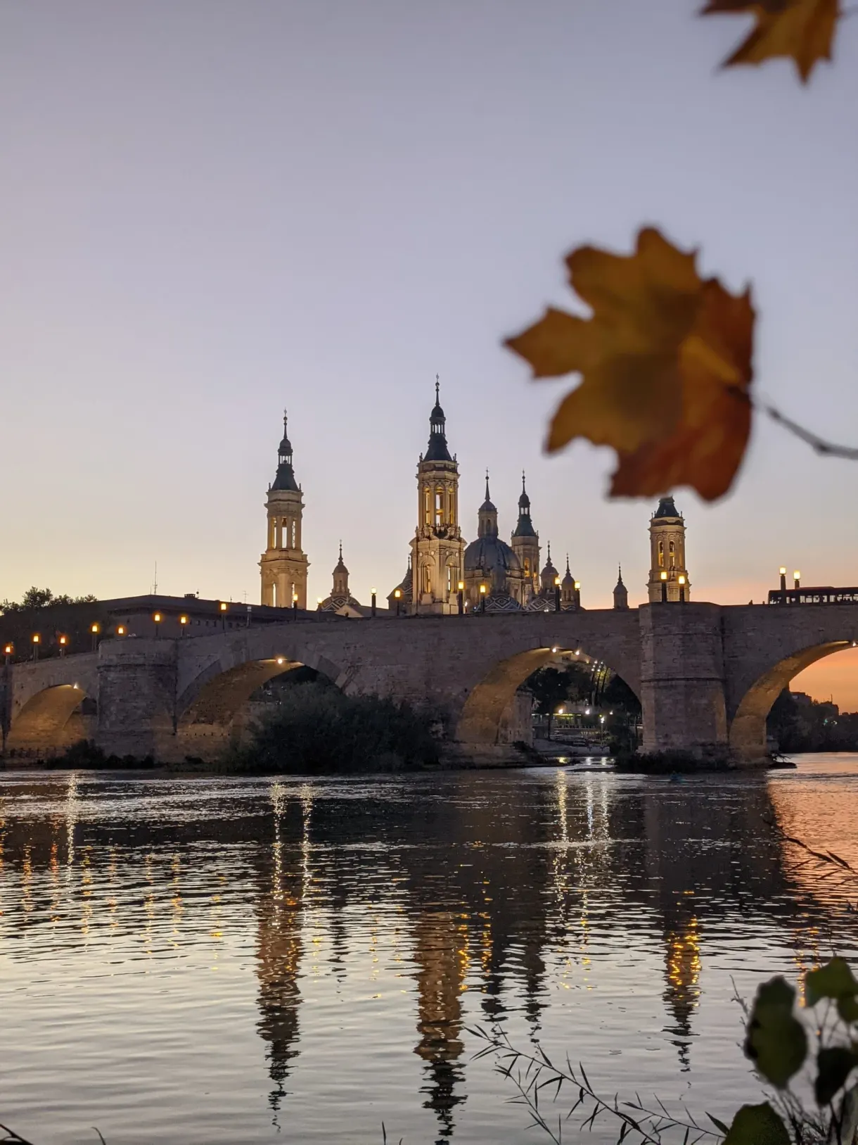 Feuille d'érable devant le pont et la basilique au crépuscule
