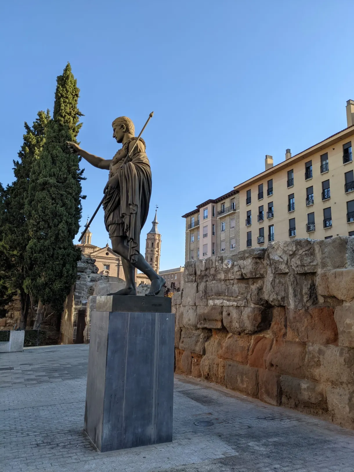 Statue de bronze d'Auguste devant les murailles romaines