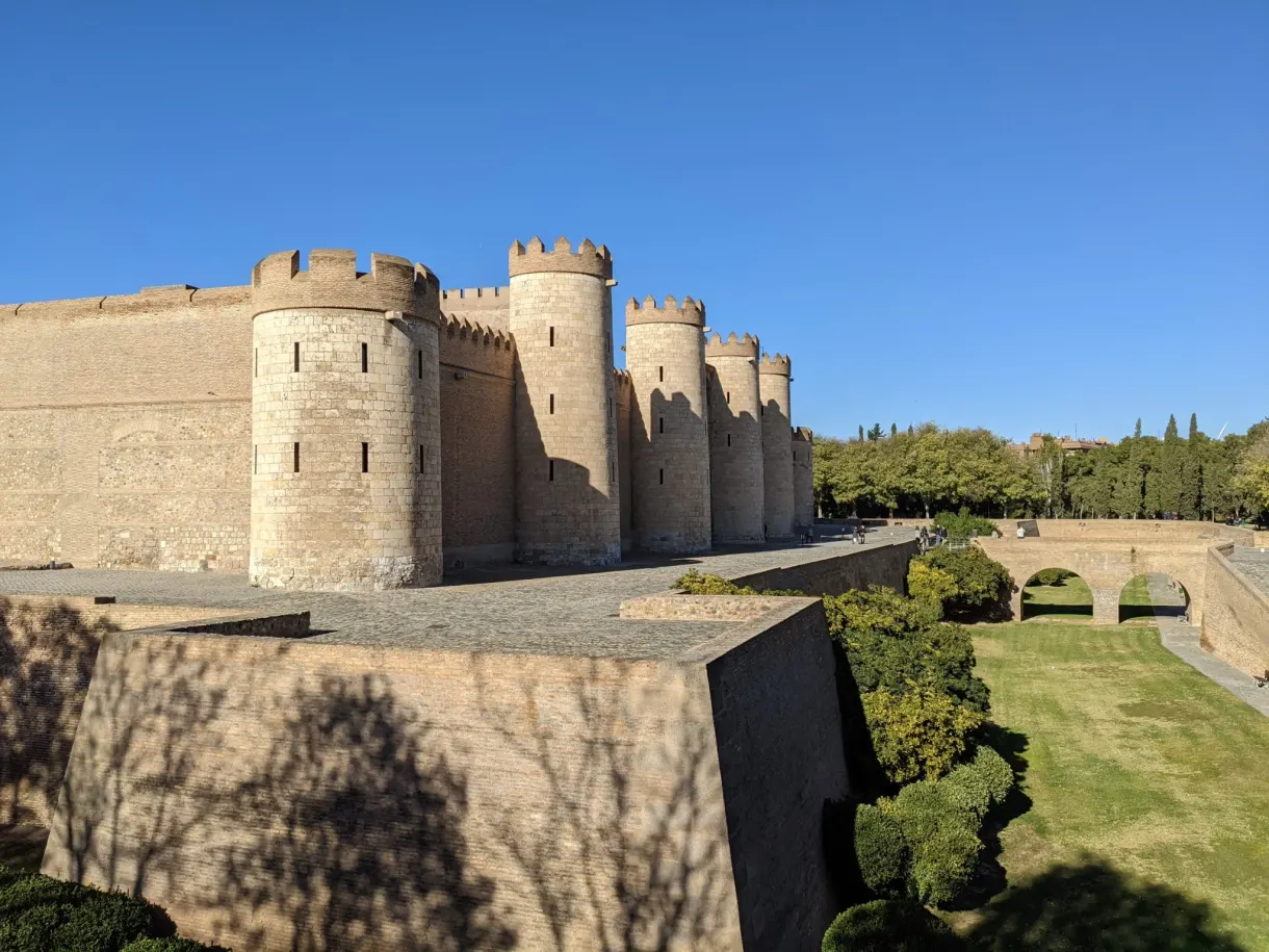 Tours de l'Aljafería bordées de pelouse et de douves