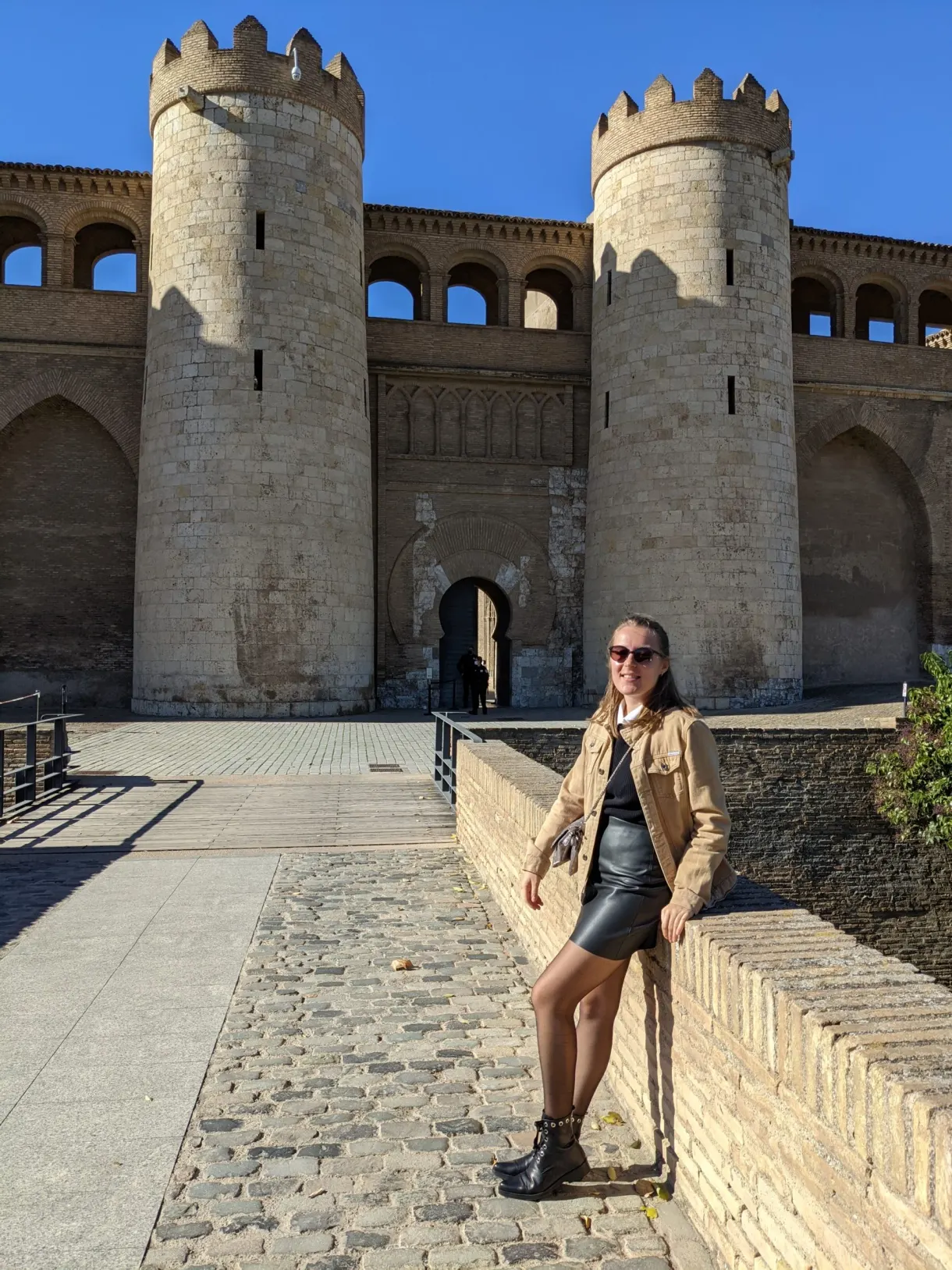 Femme sur la passerelle menant à la porte du palais