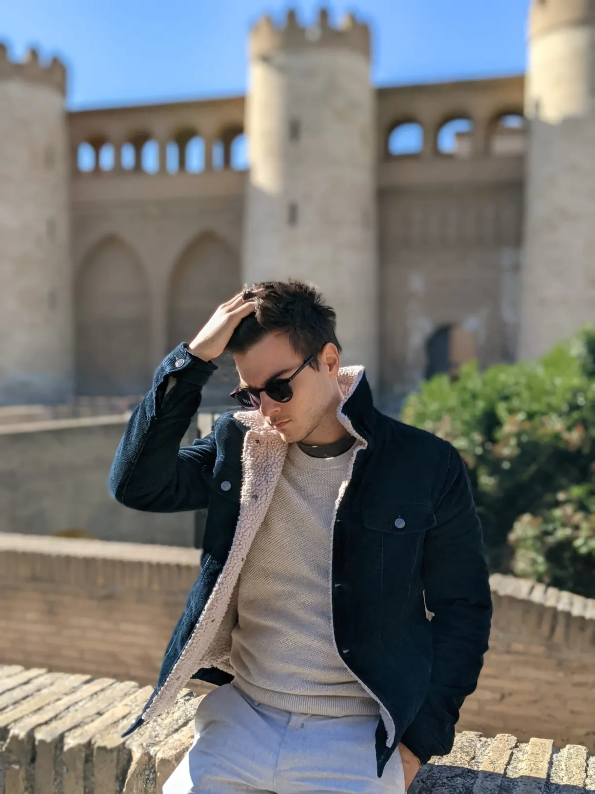 Homme en veste sombre devant les remparts dorés